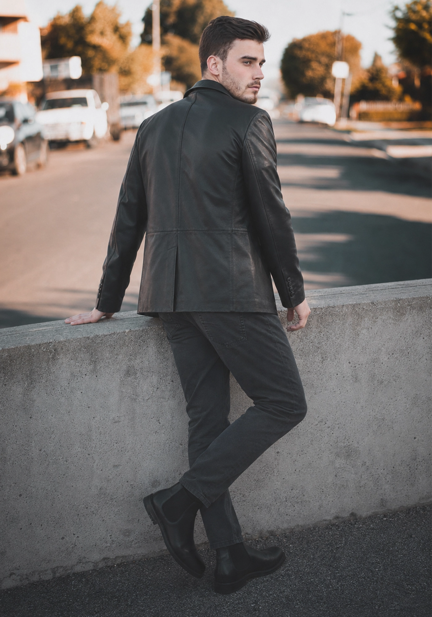 Black men's blazer with lapel collar, long sleeves, stitched panel seams, cuff buttons, and a straight extended hem shown from multiple angles