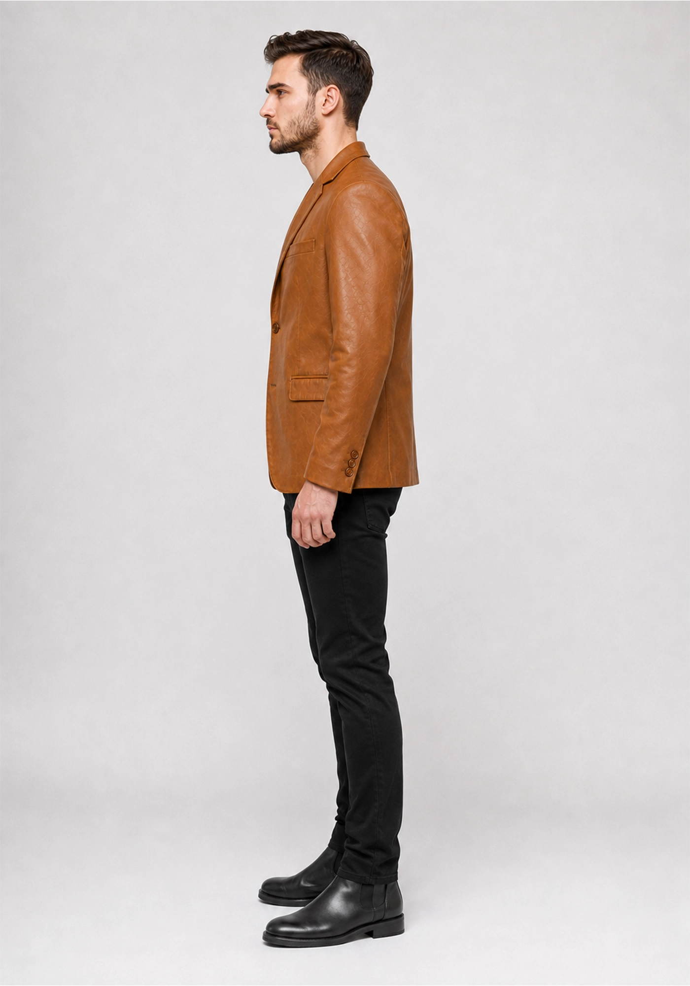Tan men's blazer jacket with lapel collar, two-button front, chest welt pocket, lower flap pockets, long sleeves, and clean back seam